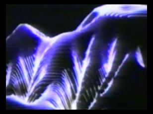 Kadr z filmu - na czarnym tle świetlisty, wypełniający niemal cały kadr kształt przypominający fluorescencyjną tkaninę o niebieskawej barwie..