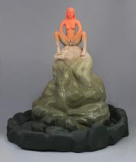 Rzeźba ukazuje młodą kobietę siedzącą z rozłożonymi nogami na szczycie stosu kamieni, jej dłonie dotykają warg sromowych, figura kobiety zabarwiona jest na pomarańczowo, stos kamieni na ciemnozielono, w rzeźbie zamontowany jest mechanizm hudrauliczny uruc