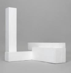 Model architektoniczny, kompozycja rzeźbiarska składająca się z białych sześciennych brył. Jedna wznosi się pionowo, jak wieża. Pozostałe leżą, połączone ze sobą.