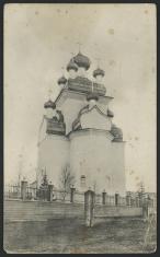 Czarno-biała fotografia przedstawiająca wysoki budynek cerkwi z jedną centralną wieżą i pięcioma niżej dookoła niej. To Preobrażenskaja cerkow w Czekujewie.