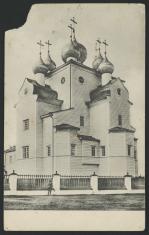 czarno-biała fotografia przedstawia jasny, rozczłonkowany i wielokondygnacyjny budynek cerkwi, główną wieżyczkę w centrum otacza pięc mniejszych. To Michajło-Archangielski Chram w Szenkursku.
