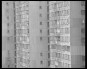 Kadr z filmu czarno-białego - ogromny wieżowiec ustawiony pod skosem, wypełniający cały kadr.