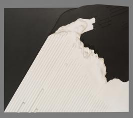 Kompozycja abstrakcyjna, reliefowa na płycie pilśniowej, z dolnej krawędzi ku górze wyrasta ukośnie ku prawej stronie biała forma złożona z drobnych ukośnych pasków, w prawym górnym narożniku czarna strefa, z lewej układająca się w trójkąt czarno-szara.