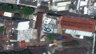 Kadr z animacji komputerowej na podstawie widoków z Google Earth. Zbliżenie na Rio De Janeiro z czarno-białym graficznym motywem umieszczonym na dachu budynku będącym schematycznym przedstawieniem głowy królika.