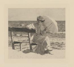 Kobieta siedząca na ławce nad brzegiem morza