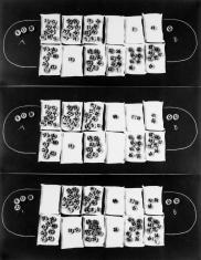 Czarno-biała reprodukcja przedstawiająca trzy kadry ułożone jeden nad drugim, na każdym plansza do węgierskiej gry kalah z innym ustawieniem żetonów. Na czarnym tle ułożone w dwóch rzędach 12 białych kartek z białymi, okrągłymi ponumerowanymi żetonami, po