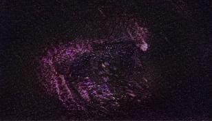 Obraz cyfrowy przedstawiający skupione w centrum drobne jasne punkty na ciemnym tle, przypominające gwiezdną mgławicę. 