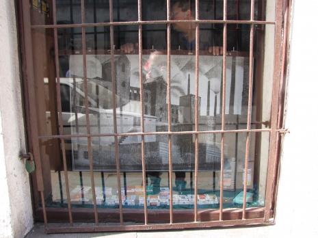 Reprodukcja Spalonej fabryki Karola Hillera w oknie wystawowym antykwariatu przy zbiegu ulic Mielczarskiego i Gdańskiej