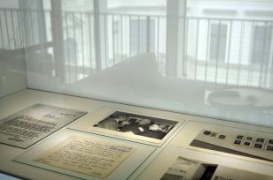 W gablocie dyskretnie oświetlonej punktowymi światłami znajduje się szereg eksponatów: listy, jeden pisany na maszynie, drugi ręcznie, fotografia z wernisażu i fotografia muzealnej ekspozycji prac artysty. W szybach gabloty odbijają się budynki muzeum